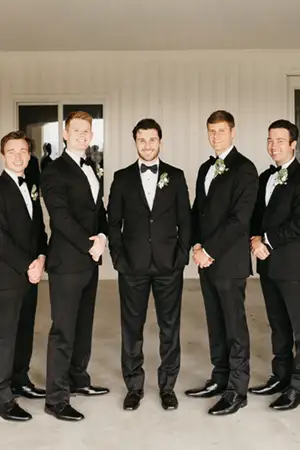 Large wedding party all wearing black tuxedos