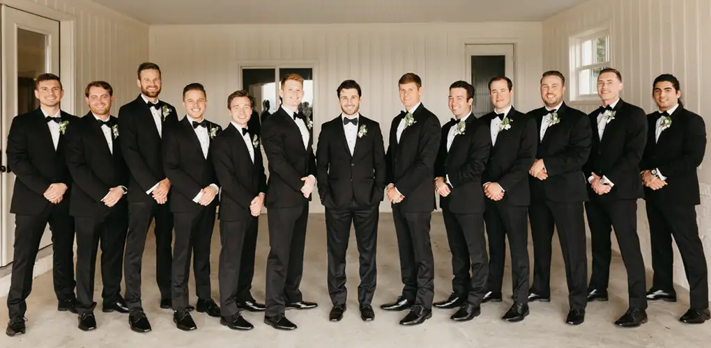 Large wedding party all wearing black tuxedos
