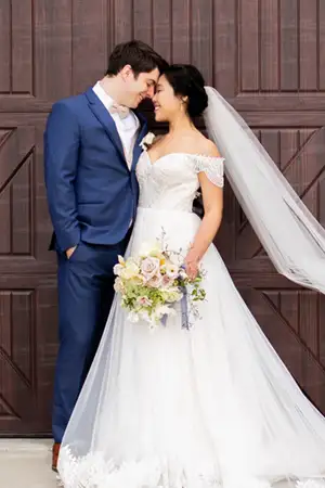 Newly married couple in front of a barn door.
