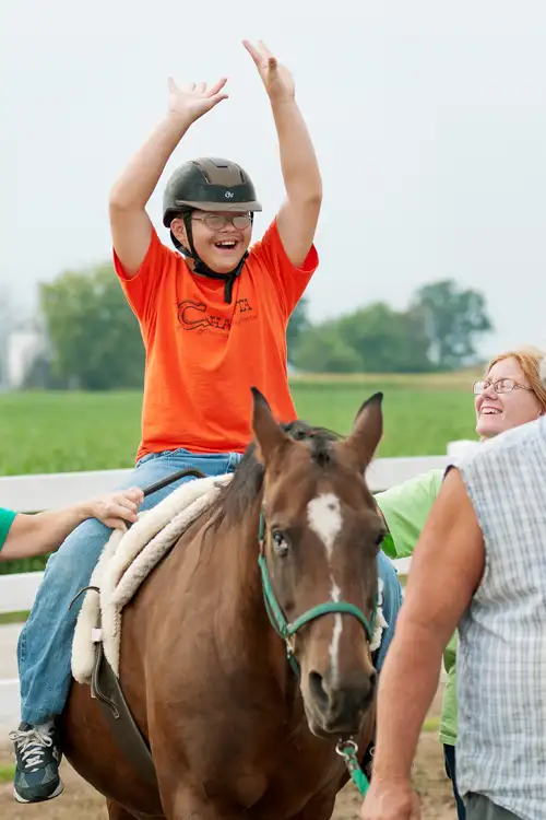 Kid riding a horse at Chakota Therapeutic Riding Center.
