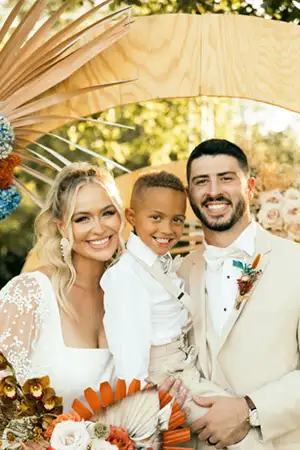 Married couple taking a photo with the ring bearer