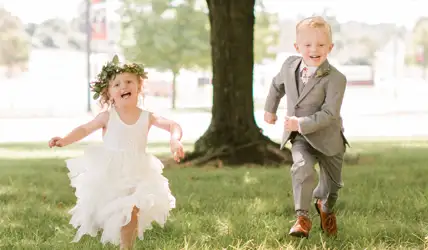 Ring bearer and Flower Girl running in a field