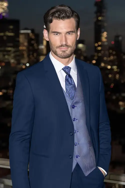 Man selected his style and is wearing a blue suit with city in the background